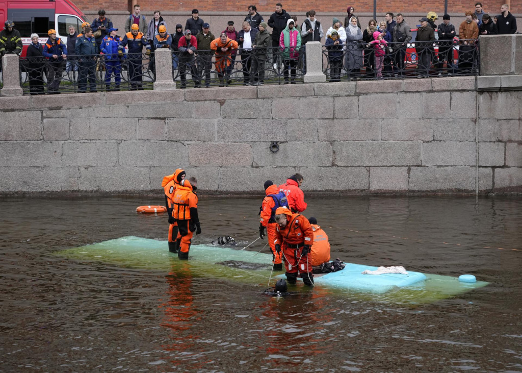 Záchranári zasahujú na mieste pádu autobusu z mosta v Petrohrade. FOTO: TASR/AP