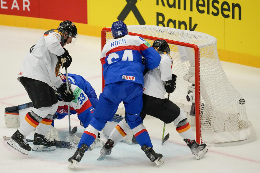 Nemecký hokejista Dominik Kahun strieľa úvodný gól na 0:1, druhý zľava brankár Slovenska Stanislav Škorvánek a druhý sprava Patrik Koch v zápase základnej B-skupiny Slovensko - Nemecko na 87. majstrovstvách sveta v ľadovom hokeji v Ostrave. FOTO: TASR/AP