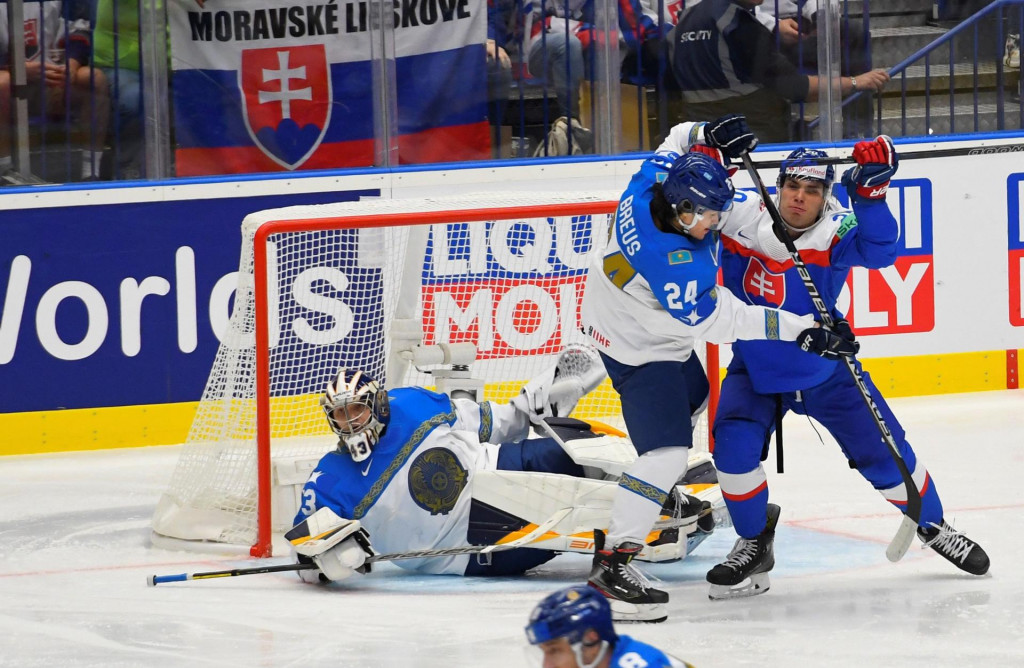 Slovenský hokejista Juraj Slafkovský (vpravo) v súboji s obrancom Dmitrijom Breusom pred bránkou Andreja Šutova (obaja Kazachstan) počas zápasu základnej B-skupiny Slovensko - Kazachstan. FOTO: TASR