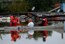 Dobrovoľníci evakuujú muža na člne zo zaplavenej oblasti v Porto Alegre v štáte Rio Grande do Sul v Brazílii. FOTO: Reuters