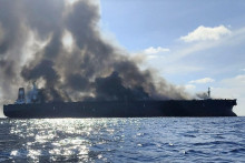 Z tankera registrovaného v Gabone stúpa dym po tom, čo plavidlo začalo horieť pri južnom pobreží Malajzie. FOTO: Reuters