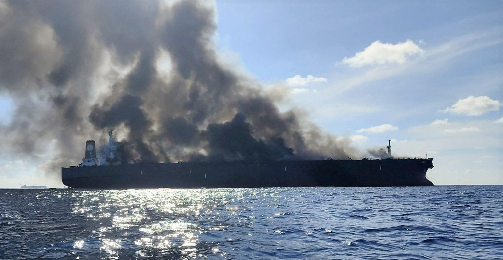 Z tankera registrovaného v Gabone stúpa dym po tom, čo plavidlo začalo horieť pri južnom pobreží Malajzie. FOTO: Reuters