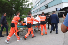 Zdravotníci prevážajú na nosidlách postreleného predsedu vlády Roberta Fica do nemocnice v Banskej Bystrici. FOTO: TASR/Ján Krošlák
