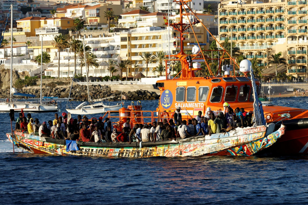Skupina migrantov v člne je vlečená plavidlom španielskej pobrežnej stráže do prístavu v Španielsku. FOTO: REUTERS