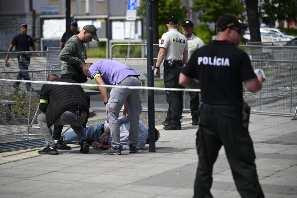 Na snímke policajti zatýkajú muža po streľbe na predsedu vlády Roberta Fica
