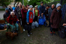 Obyvatelia oblasti Vovčanska, ktorí utiekli pred ruskými vojenskými útokmi, sa zhromažďujú v areáli evakuačného centra v Charkovskej oblasti. FOTO: REUTERS