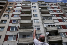 Mile Ľudovit, sused strelca, ktorý sa pokúsil o atentát na premiéra Roberta Fica, ukazuje okno bytu strelca v Leviciach. FOTO: REUTERS