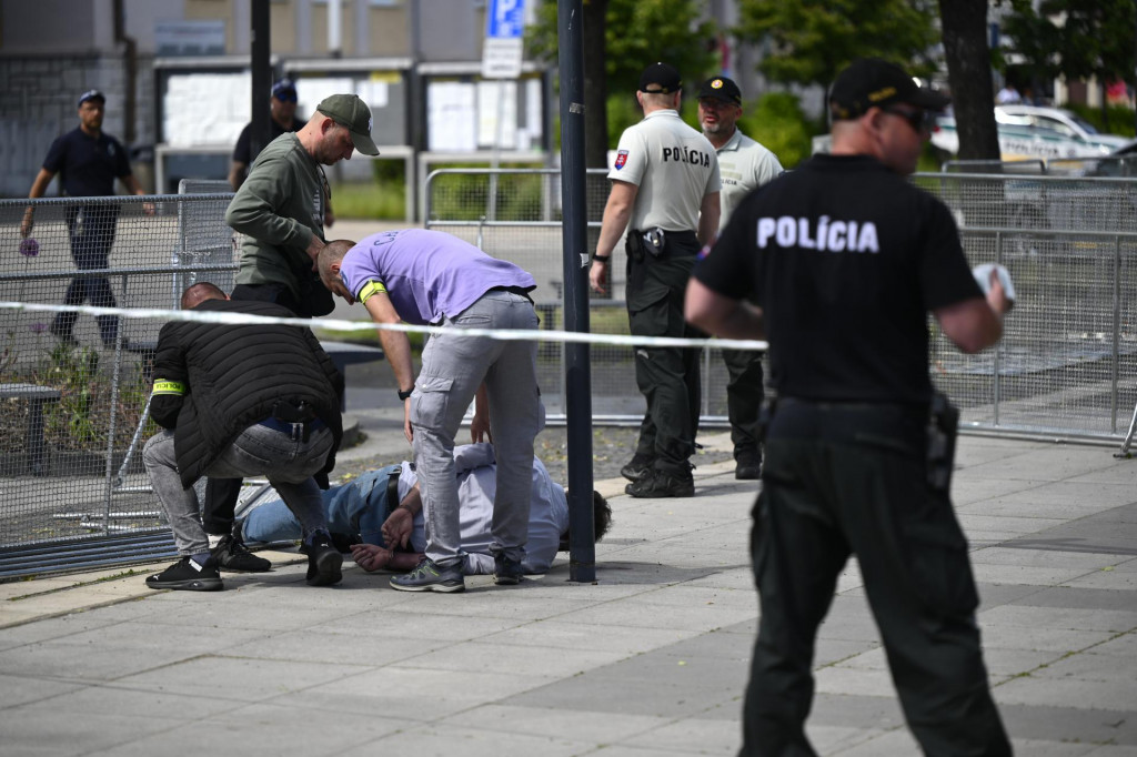 Policajti zatýkajú muža po streľbe na predsedu vlády Roberta Fica na výjazdovom rokovaní vlády v Handlovej v okrese Prievidza. FOTO: TASR/Radovan Stoklasa