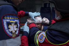 Záchranári ošetrujú zraneného miestneho obyvateľa po ruskom leteckom útoku na obytnú štvrť v meste Charkov na severovýchode Ukrajiny. FOTO: TASR/AP