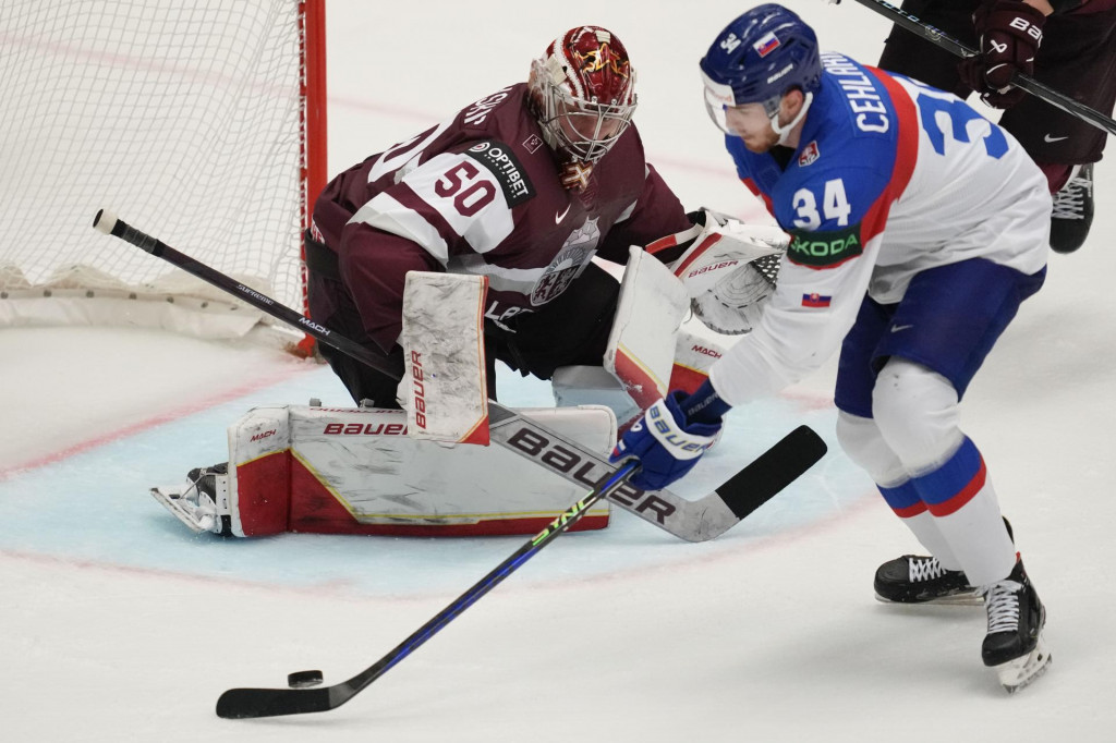 Lotyšský brankár Kristers Gudlevskis (vľavo) bráni pred Slovákom Petrom Cehlárikom v zápase B-skupiny Slovensko - Lotyšsko na MS v ľadovom hokeji 2024 v Ostrave. FOTO: TASR/AP