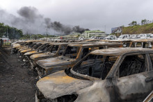 Zhorené autá po nepokojoch v meste Noumea, v Novej Kaledónii.  FOTO: TASR/AP