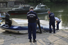 Policajní experti skúmajú trosky motorového člna vo vojenskom prístave v severnej časti Budapešti. FOTO: TASR/DUNA/MTI/Peter Lakatos
