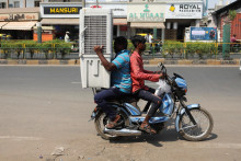 Muži prepravujú chladič vzduchu na dvojkolesovom vozidle počas horúceho letného dňa v indickom meste Ahmedabad. FOTO: Reuters