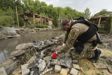 Pyrotechnik kontroluje úlomky ruskej rakety po útoku, ktorý zasiahol rekreačnú oblasť na predmestí Charkova na severovýchode Ukrajiny. FOTO: TASR/AP