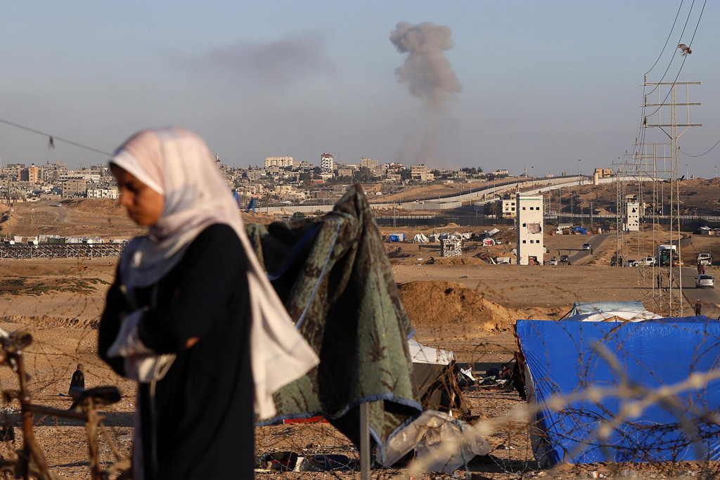 Dym po izraelskom nálete na budovy v blízkosti oddeľujúceho múru medzi Egyptom a Rafahom na juhu pásma Gazy. FOTO: TASR/AP