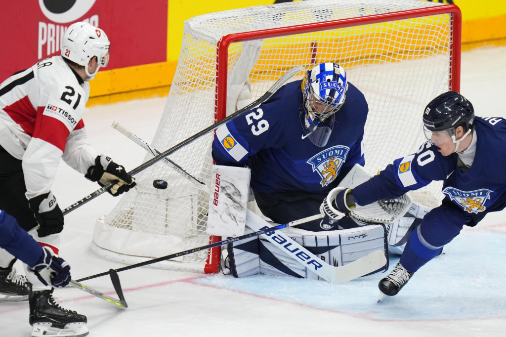 Švajčiarsky hráč Kevin Fiala sa pokúša skórovať cez fínskeho brankára Harriho Sateriho a Fína Juusa Riikolu v zápase A-skupiny Fínsko - Švajčiarsko na MS v ľadovom hokeji 2024 v Prahe. FOTO: TASR/AP