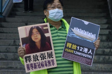 Prodemokratický aktivista drží 28. decembra 2020 pred styčným úradom čínskej ústrednej vlády v Hongkongu plagáty s obrázkom čínskej občianskej novinárky Čang Čan. FOTO: TASR/AP