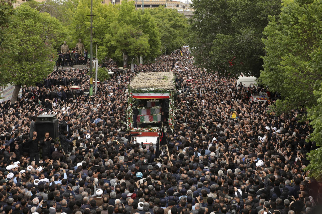 Ľudia sa zhromažďujú okolo nákladného auta vezúcom rakvu s telesnými pozostatkami zosnulého iránskeho prezidenta Ebráhíma Raísího a jeho spolupracovníkov, ktorí v nedeľu zahynuli pri havárii vrtuľníka. FOTO: TASR/AP