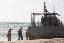 Americkí vojaci pracujú na vyslobodení plavidla, ktoré uviazlo po tom, čo nabehlo na plytčinu a snažia sa pomôcť inému uviaznutému plavidlu používanému na doručovanie pomoci Palestínčanom cez nové mólo postavené Spojenými štátmi. FOTO: Reuters