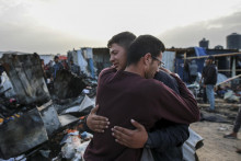 Palestínčania sa objímajú na mieste deštrukcie po izraelskom bombardovaní pásma Gazy v Rafahu. FOTO: TASR/AP