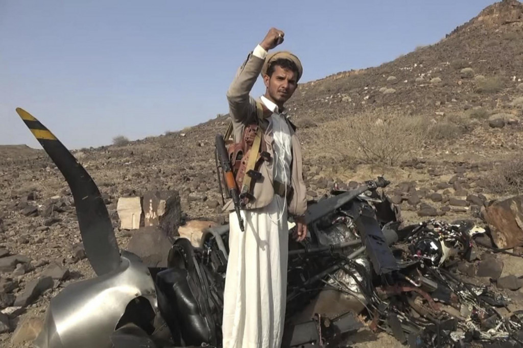 Príslušník jemenských povstalcov húsíov sa teší pred troskami pravdepodobne amerického bezpilotného lietadla MQ9, ktoré zostrelili jemenské ozbrojené sily v meste Saada. FOTO: TASR/AP