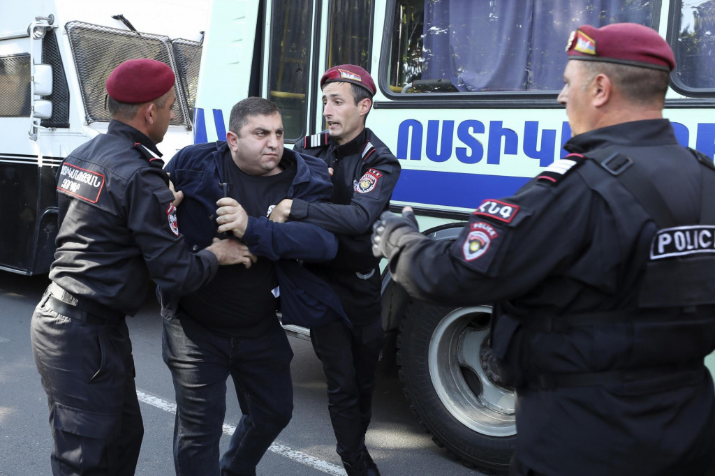 Policajti zadržujú demonštranta počas protivládneho protestu v Jerevane. FOTO: TASR/AP