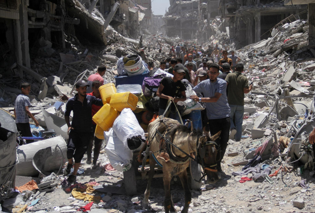 Palestínčania idú na cestu, keď kontrolujú škody po tom, čo sa izraelské sily stiahli z utečeneckého tábora Jabalia po nálete v severnom pásme Gazy. FOTO: Reuters