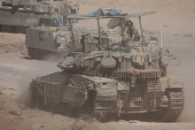 Izraelský vojak sedí na vrchole tanku. FOTO: Reuters