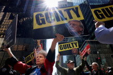 Protestujúci s transparentmi pred budovou Trump Tower deň po rozsudku v trestnom procese s bývalým prezidentom USA Donaldom Trumpom. FOTO: REUTERS/Andrew Kelly