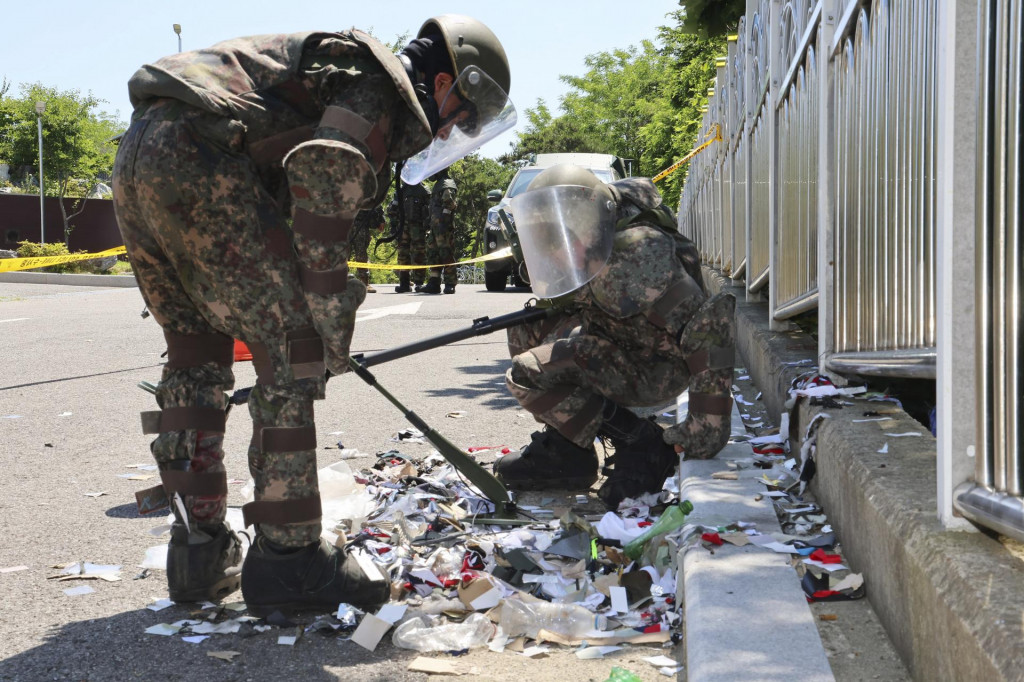 Juhokórejskí vojaci v ochranných odevoch kontrolujú odpadky z balónov v meste Inčchon, ktoré vypustila Severná Kórea do vzdušného priestoru Južnej Kórey. FOTO: TASR/AP