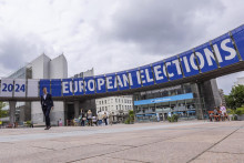 Ľudia kráčajú pred Európskym parlamentom v Bruseli. FOTO: TASR/AP