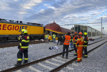 Hasiči stoja vedľa dvoch vlakov po zrážke v Pardubiciach. FOTO: TASR/AP