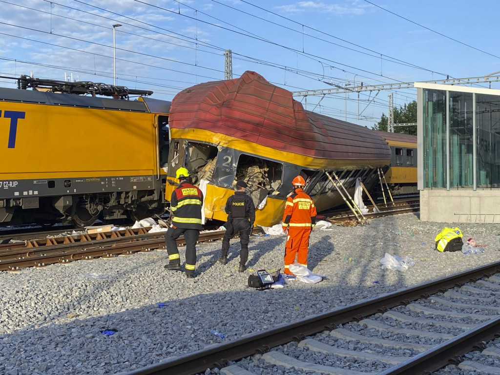 Hasiči stoja vedľa dvoch vlakov po zrážke v Pardubiciach 6. júna 2024. FOTO: TASR/AP