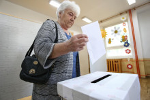 Volička vhadzuje obálku s hlasovacím lístkom do volebnej schránky vo voľbách do Európskeho parlamentu. FOTO: TASR/Daniel Stehlík