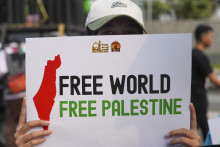 Demonštrant drží transparent počas zhromaždenia na podporu Palestíny pred americkým veľvyslanectvom v indonézskej metropole Jakarta. FOTO: TASR/AP