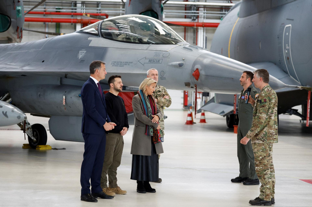 Ukrajinský prezident Volodymyr Zelenskij, belgický premiér Alexander De Croo a belgická ministerka obrany Ludivine Dedonder stoja pri F-16 v deň stretnutia s inštruktormi výcviku na leteckej základni Melsbroek neďaleko Bruselu. FOTO: Reuters