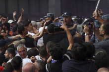 Demonštrant sa háda s policajtmi počas protestov proti premiérovi Nikolovi Pašinjanovi. Vyše dve desiatky demonštrantov zadržala v piatok arménska polícia na protivládnom proteste, ktorý sa konal v hlavnom meste Jerevan proti územným ústupkom premiéra Nikolu Pašinjana voči Azerbajdžanu. FOTO: TASR/AP