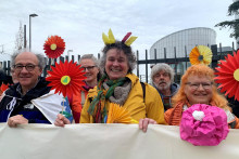 Podporovatelia združenia Senior Women for Climate Protection držia pred Európskym súdom pre ľudské práva v Štrasburgu papierové kvety a transparent. FOTO: Reuters