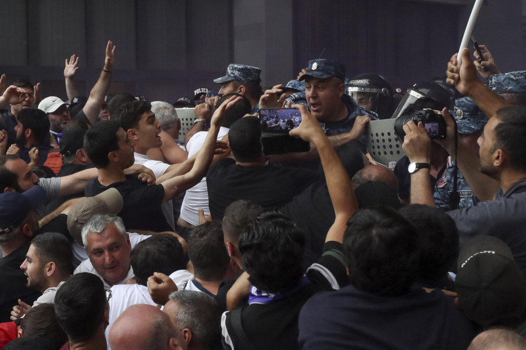 Demonštrant sa háda s policajtmi počas protestov proti premiérovi Nikolovi Pašinjanovi. Vyše dve desiatky demonštrantov zadržala v piatok arménska polícia na protivládnom proteste, ktorý sa konal v hlavnom meste Jerevan proti územným ústupkom premiéra Nikolu Pašinjana voči Azerbajdžanu. FOTO: TASR/AP