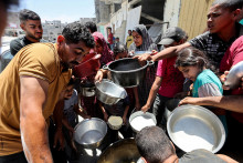 Palestínčania sa zhromažďujú, aby dostali jedlo varené v charitatívnej kuchyni v blízkosti domov zničených pri izraelskej vojenskej ofenzíve. FOTO: Reuters