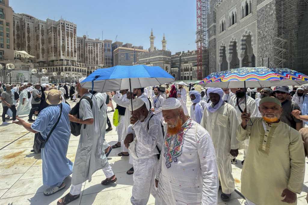 Moslimovia sa chránia dáždnikmi počas horúčav po modlitbách pred Veľkou mešitou na púti hadždž v saudskoarabskom posvätnom meste Mekka. FOTO: TASR/AP
