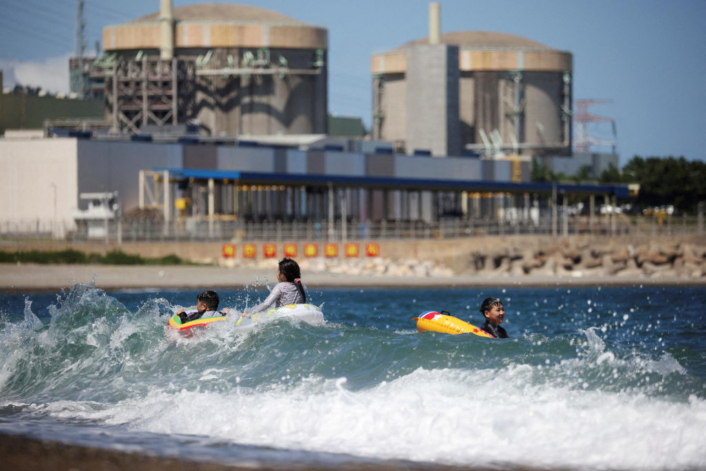Deti sa hrajú vo vode a v pozadí vidieť jadrovú elektráreň Wolseong v Južnej Kórei.

FOTO: REUTERS
