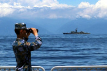 Čínsky vojak ďalekohľadom sleduje more. FOTO: TASR/AP