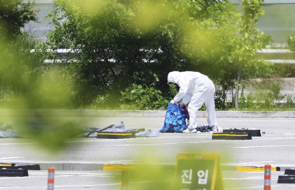 Pracovník v ochrannom odeve zbiera odpadky z balóna, ktoré pravdepodobne vypustila Severná Kórea v juhokórejskom meste Siheung. FOTO: TASR/AP