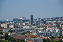 Na snímke Bratislavský hrad (uprostred v pozadí), Dóm sv. Martina (vľavo), Národná banka Slovenska (NBS, výšková budova uprostred) a budova Slovenského rozhlasu, ktorá má tvar prevrátenej pyramídy (vpravo od NBS) v Bratislave v piatok 18. augusta 2023. V pozadí sú veterné turbíny v Rakúsku. FOTO TASR - Pavol Zachar *** Local Caption *** profil budovy pohľad hlavné mesto bratislava bratislavská mestská časť dominanty Staré Mesto veterné turbíny Rakúsko FOTO: Pavoil Zachar