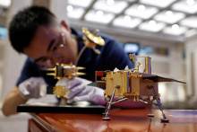 Člen personálu zostavuje model lunárnej sondy Čchang-e 6. FOTO: Reuters
