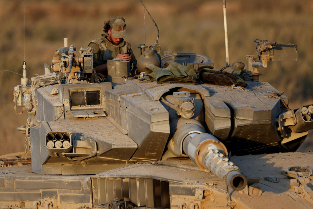Izraelský vojak na tanku drží pozíciu blízko izraelsko-gazskej hranice. FOTO: Reuters