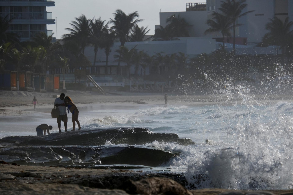 Odvážlivci, ktorí trávia čas na pláži pred príchodom hurikánu Beryl v Cancúne. FOTO: Reuters