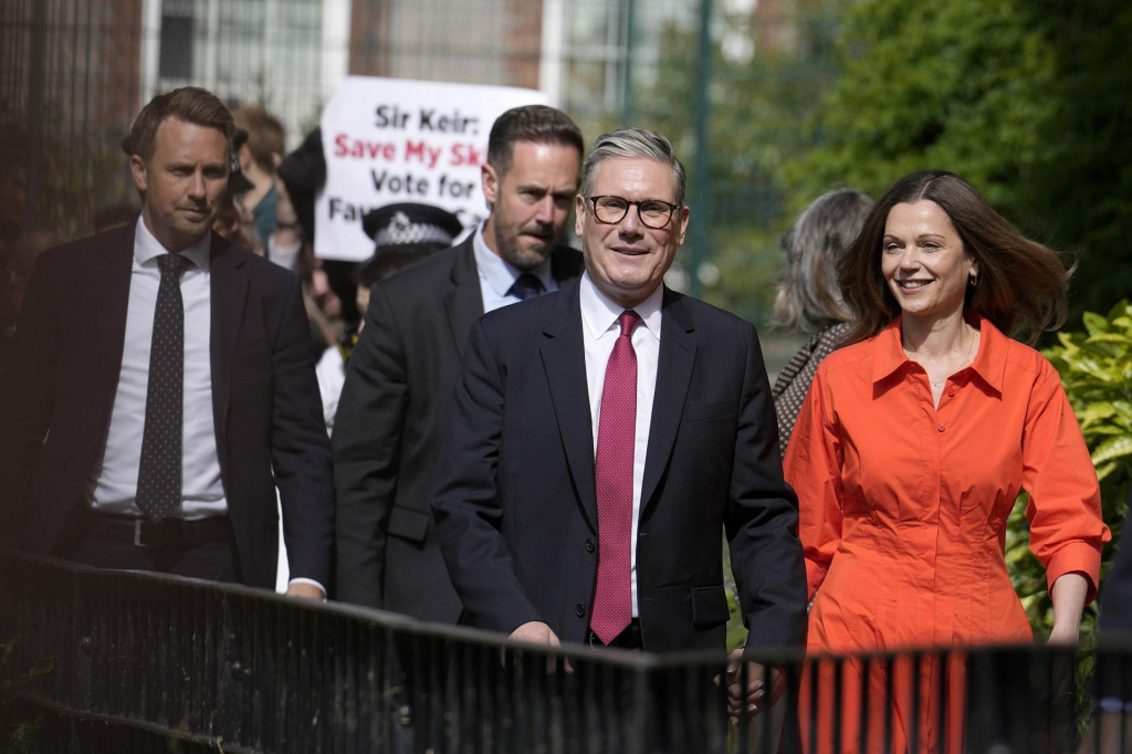 Líder Labouristickej strany Keir Starmer a manželka Victoria prichádzajú do volebnej miestnosti, aby odovzdali svoj hlas v Londýne. FOTO: TASR/AP