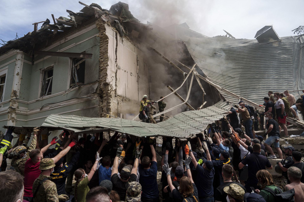 Príslušníci záchraných zložiek zasahujú pred detskou nemocnicou po ruskom raketom útoku v ukrajinskej metropole Kyjev. FOTO: TASR/AP